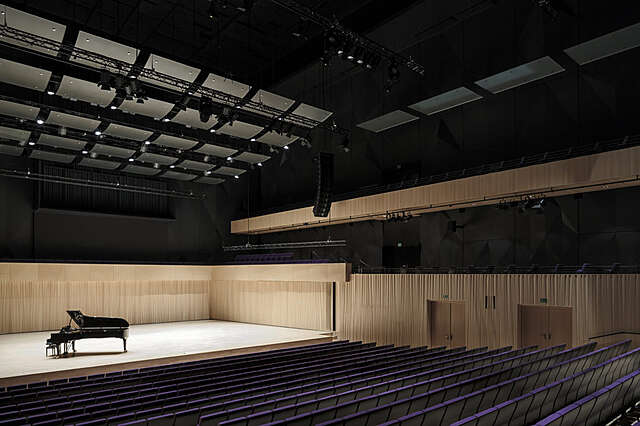 A hall with a grand piano on the stage
