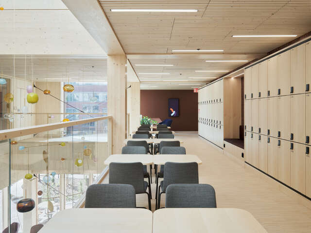 Kirjoitus An interior photo of a timber-clad upper level featuring a study area.