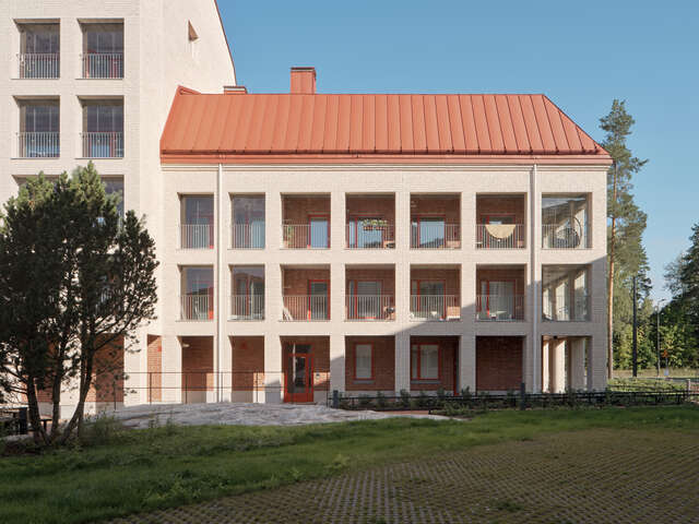 Three-storey apartment building with a red roof.