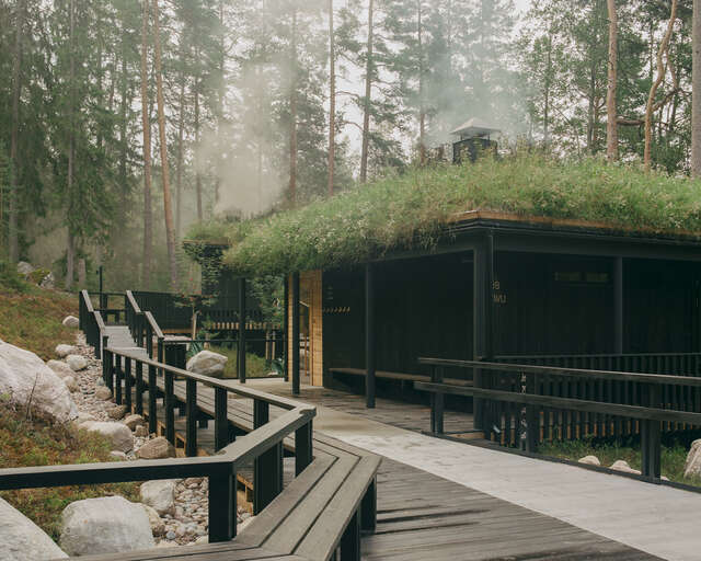 A wooden cooling-off area in front of the building with green roof.