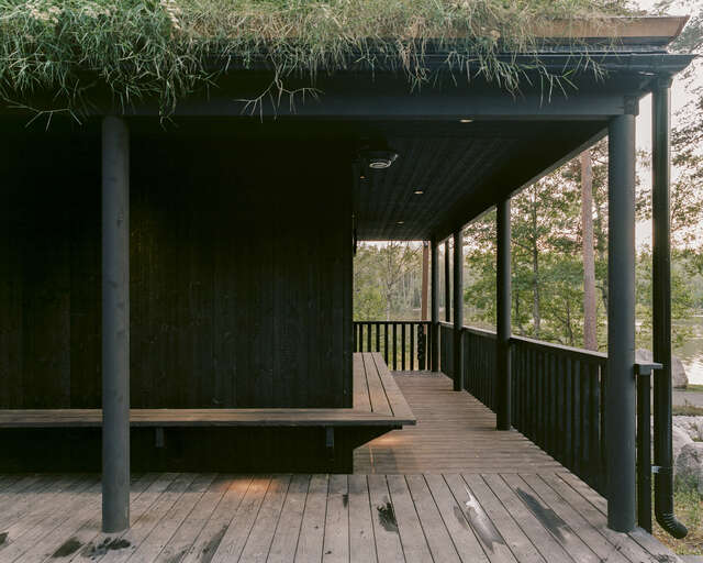 A covered wooden cooling-off walkway overlooking to a lake.