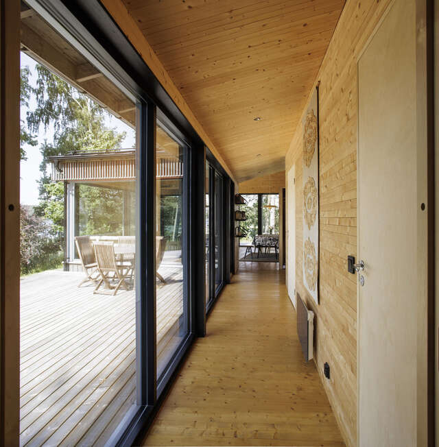 Corridor with all wooden surfaces and a glazed wall on one side