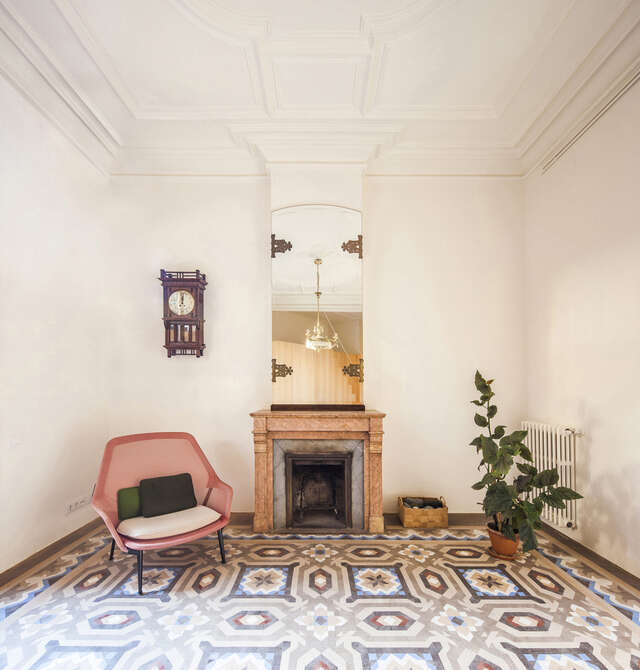 A room with a patterned carpet and fireplace