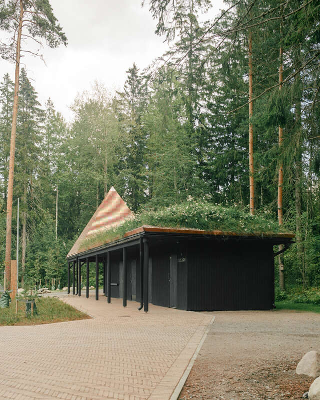 A low building with tetrahedron structure rising from the back of the roof.