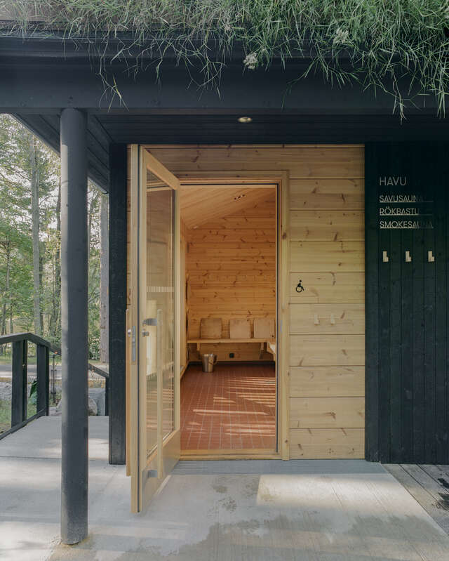 An open door reveals a wooden changing room with seating.
