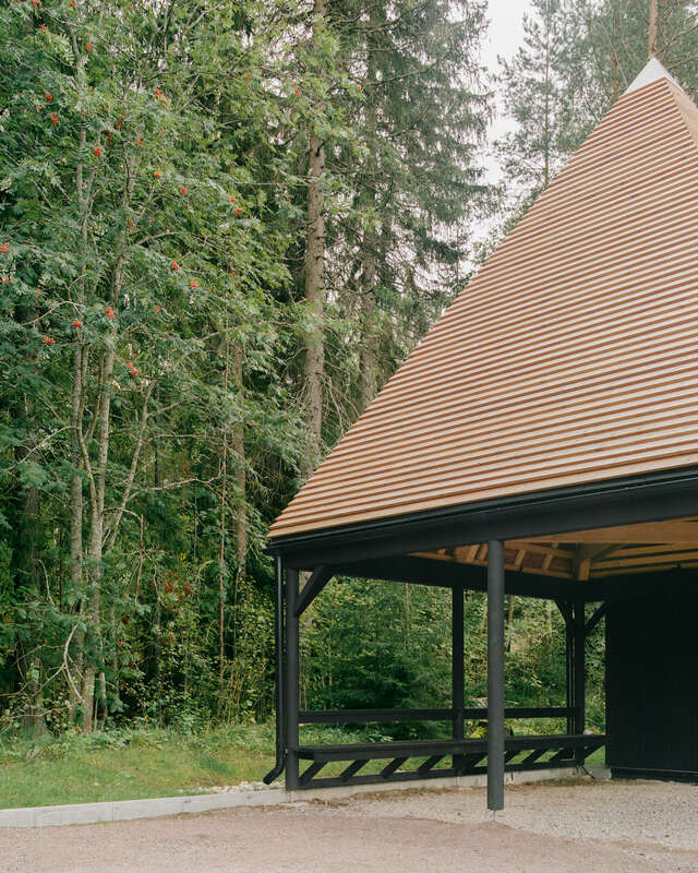 An outdoor space with a tetrahedron-shaped roof covering a seating area.