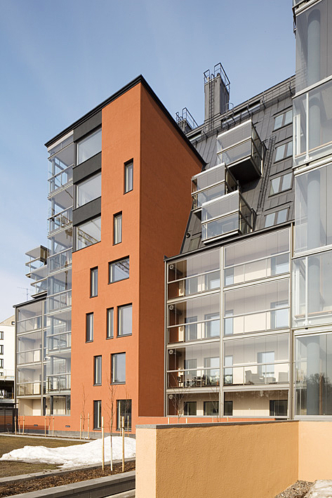 Apartment building exterior with glass and red-brick elements.