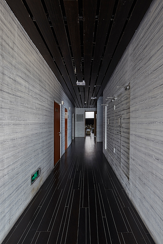 Grey-coloured corridor with red doors on the left