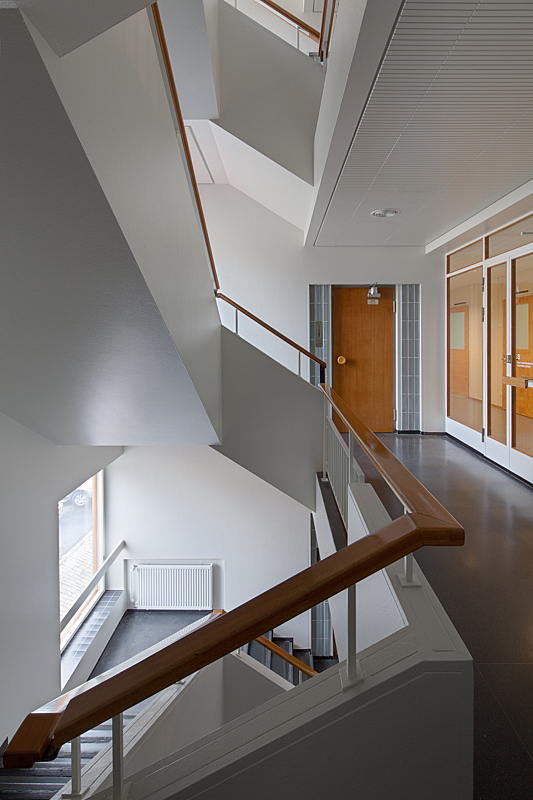 White staircase with wooden handrail