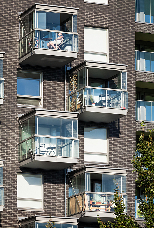 Brown-brick facade with glazed balconies