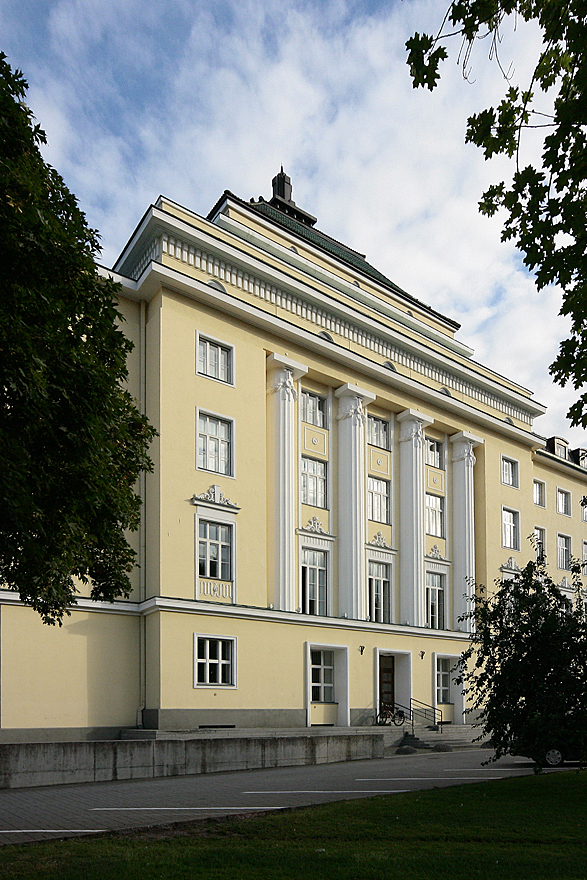 Yellow multiple storey building with white structural elements and decorations.