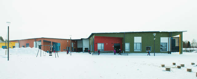 School yard on a snowy day, the school building is colorful.