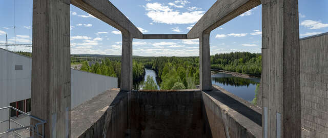 Image of a concrete built log crane alongside with the beautiful river landscape.
