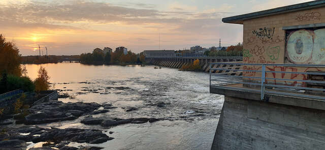 Rapids and a dam building with graffitis in evening sunvening