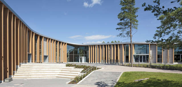 The school yard is surrounded by the two wings of the building that have vertical beams supporting the extending roof.