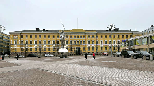 front facade of a large empire style building seen across a market square