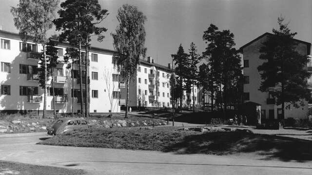 Green area in front of white lamel houses