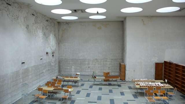 Before image of the library with walls full of chipped paint.