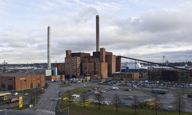 Power station with a parking area in the front and port view in the background