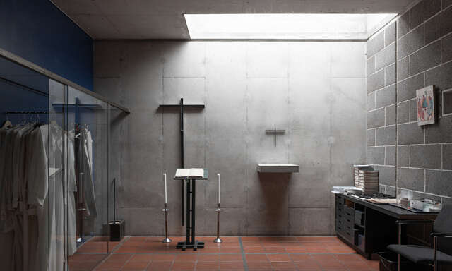 A small room with a skylight. The walls and ceiling are concrete and the floor is paved.