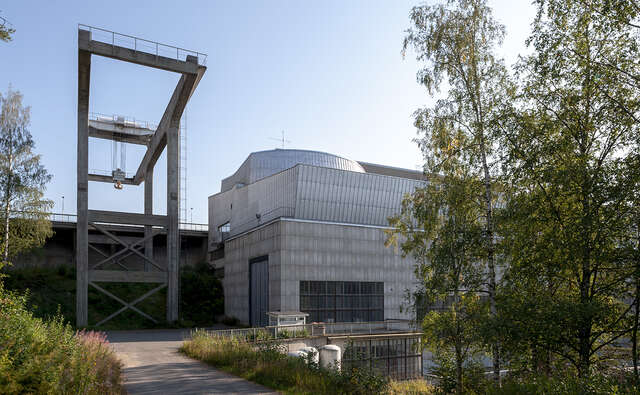 Photo of a grider crane frame next to the power plant building.