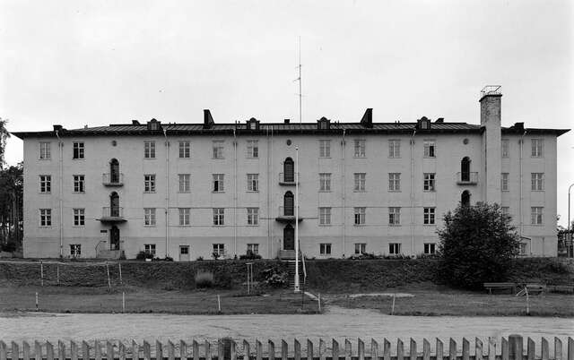 Façade of the three-storey building with a front garden