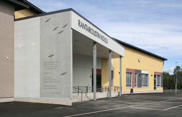 Entrance to the school with a poem and bird drawings on the wall.