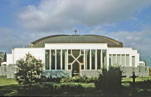 Facade with white painted timber cladding and a copper dome.