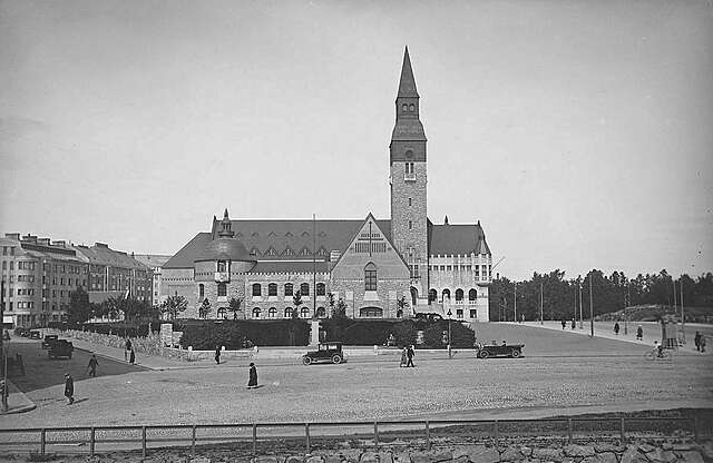 Black and white photograph of national-romantic building with a tower, granite façade and steatite decoration