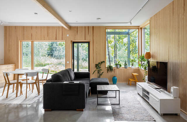 A modern living room with a television, sofa and dining area.