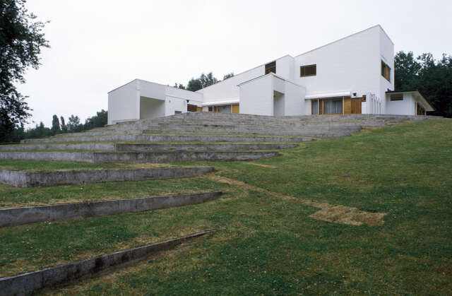 Low rock stairs and lawn to the white house on top