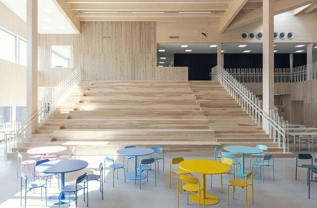 A lobby with a large wooden staircase and a colourful seating area