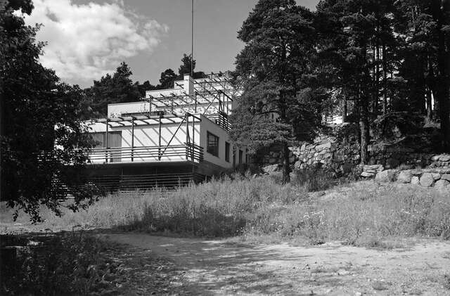 The stepped terrace house rising steeply, surrounded by trees and grass