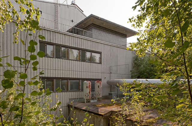 Image of the facade covered in metal and brick. Ribbon windows let the light in.