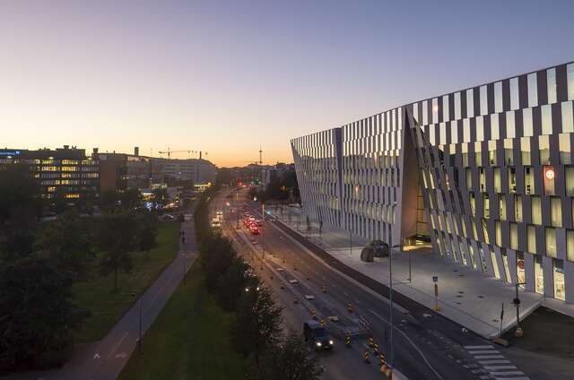 Grey and glass facade of the headquarters during sunset.