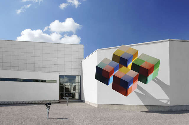 White facade with colorful cubes hanging on the wall.