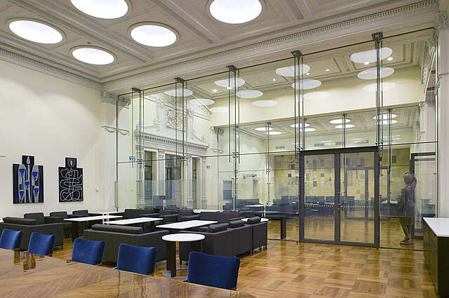Cream colored interior with black and blue collared furniture.
