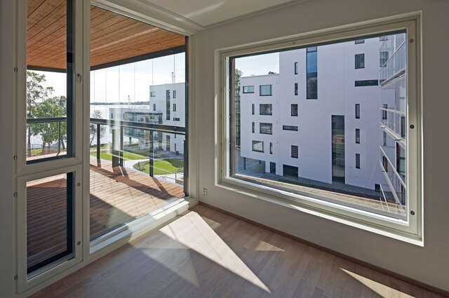 View from the glass balcony and the window to a modern white apartment building at the coast.