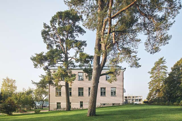 An old stone building in the middle of a lush green field.