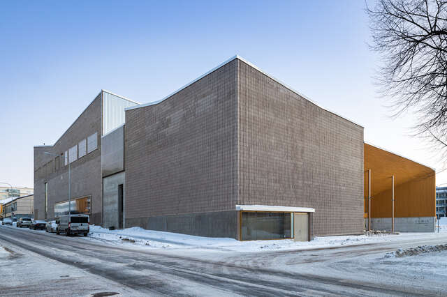 A large cube-shaped building on a snowy street corner.
