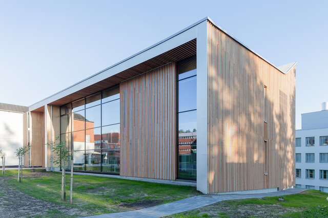 A large structure with wooden walls and large glass windows.