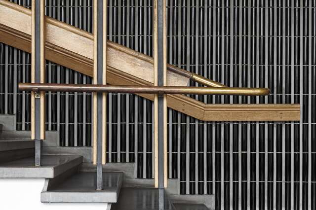 Wooden railings with metal details and a black tile background.