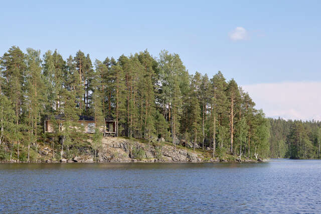 A large rocky island filled with trees seen from the water.