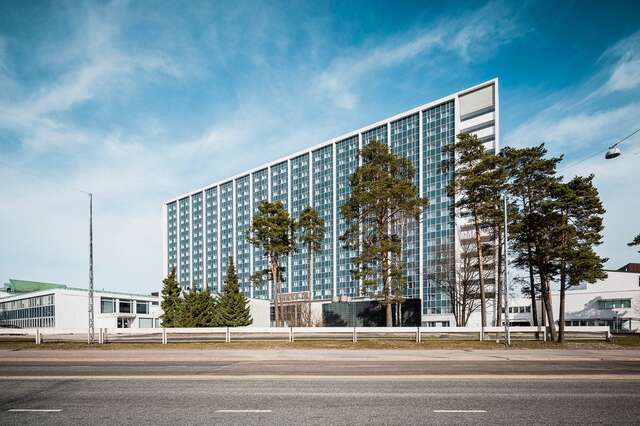 Hospital building behind a street on a sunny day.