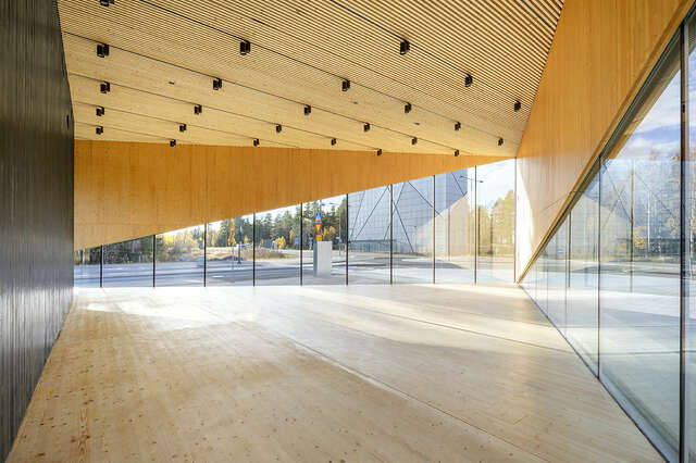 An empty space with wood ceilings and glass walls.