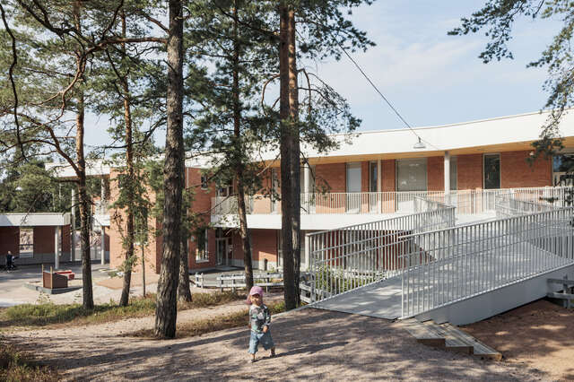 A large brick building with a small child in front of it