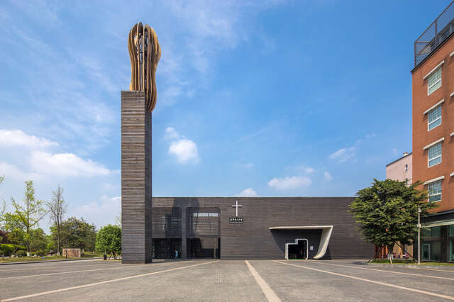 Grey-coloured square building with a tower on the left side