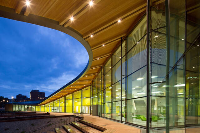 Semiarch canopy over a glass façade viewing the school interior