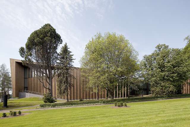 Wooden facade behind trees.