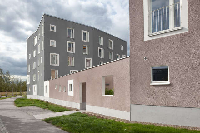 Two five-storey block houses connected with a lower wall with an entrance and square holes